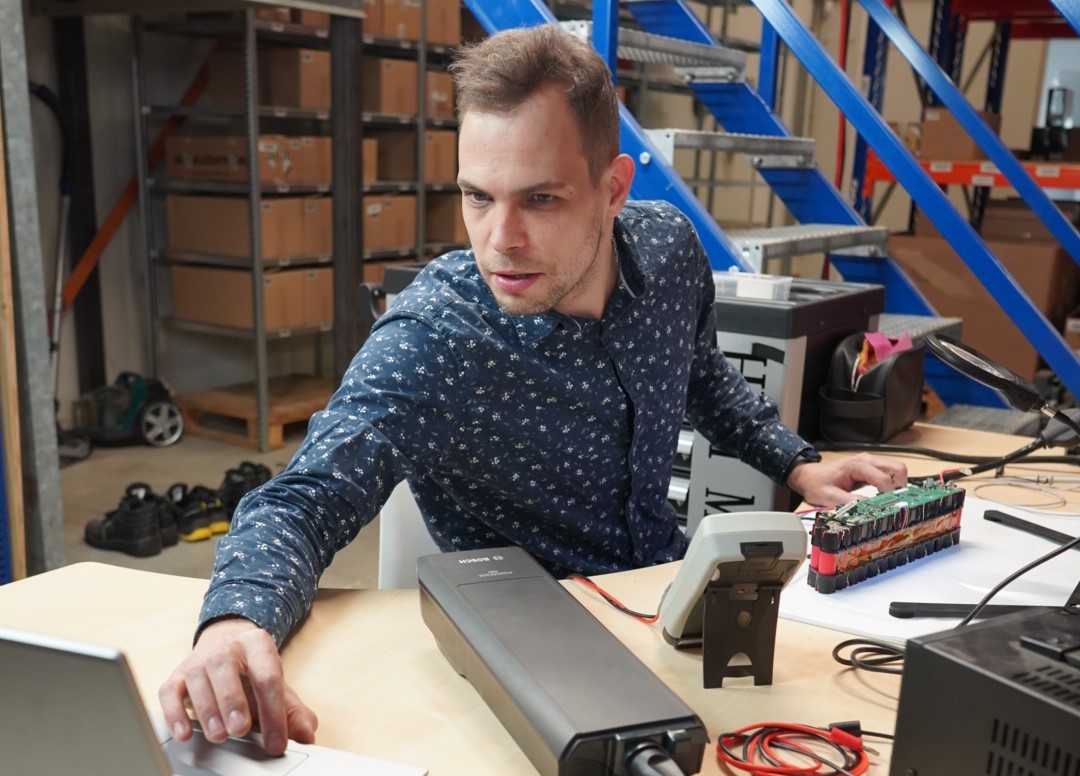 Dette billede viser e-bikeaccu.co.uk's elektriske chef, der omhyggeligt udfører test af de nye cykelbatterier.