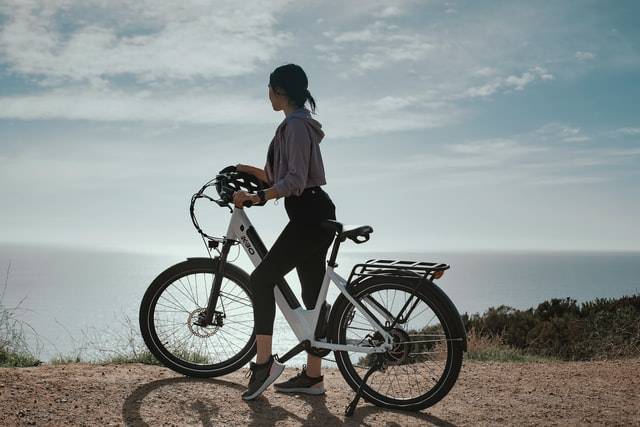 elcykel med solen og en bjergklippe i baggrunden